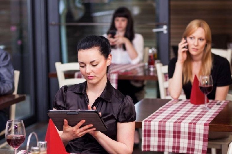 Woman using a tablet computer in a restaurant