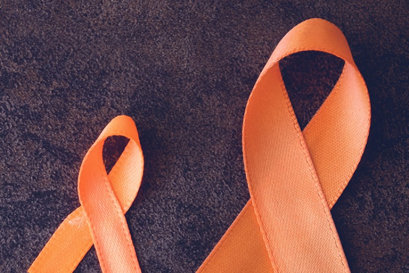Two orange ribbons on a wooden table